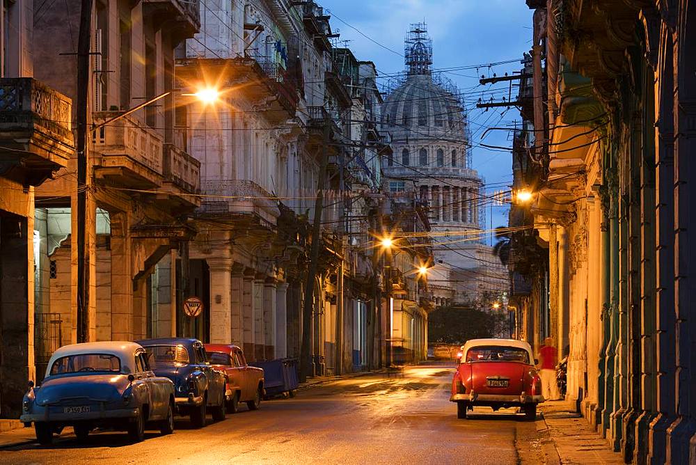 Old American vintage cars on a Havana street near El Capitolio building at dawn, Havana, Cuba, West Indies, Caribbean, Central America