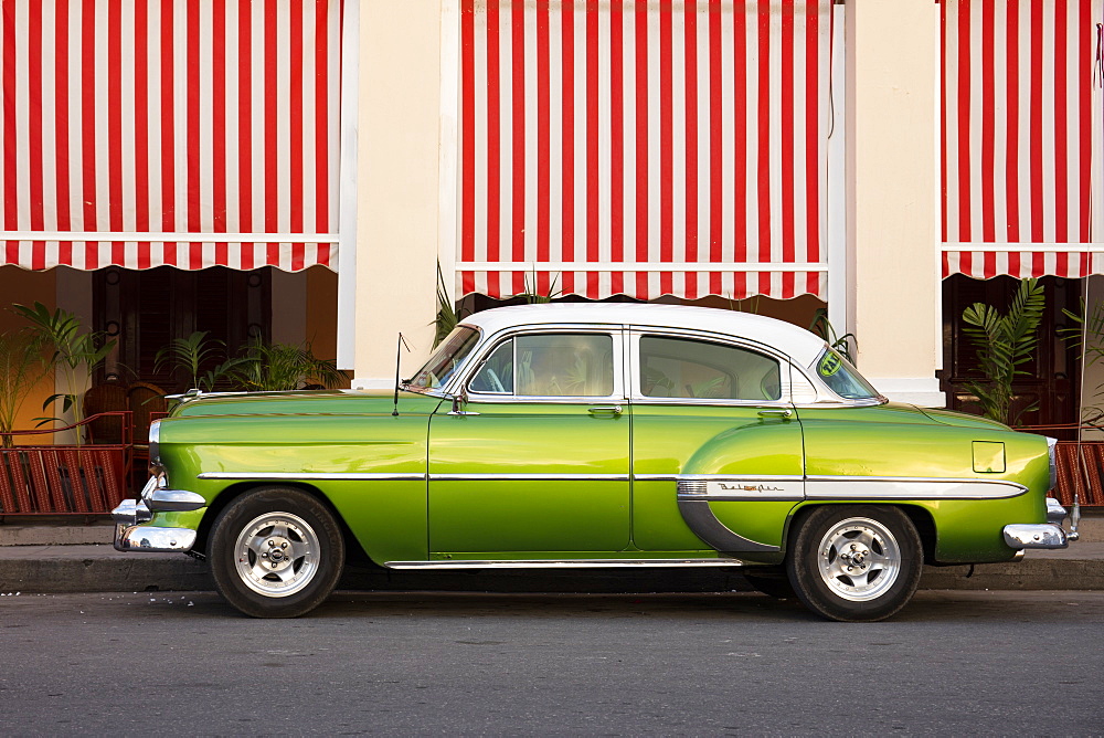 Green vintage American car parked in front of cafe, Cienfuegos, UNESCO World Heritage Site, Cuba, West Indies, Caribbean, Central America