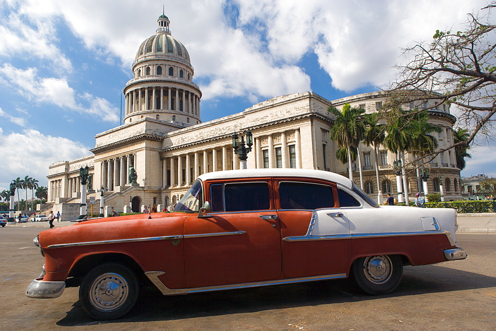 A red and white American car outside El Capitolio in Havana, Cuba, West Indies, Caribbean, Central America