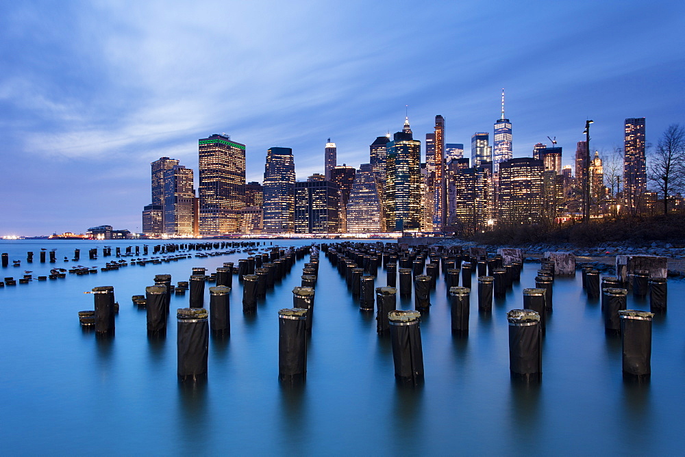 Lower Manhattan skyline with wooden posts from an old pier in the foreground. New York City, New York, United States of America, North America