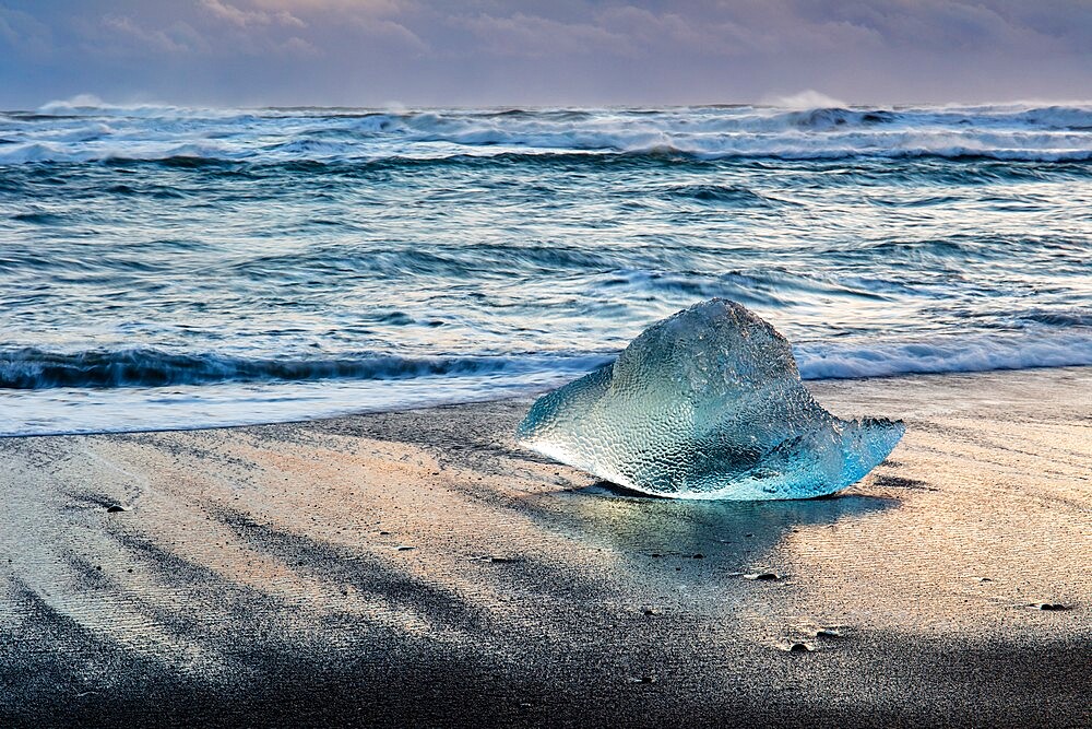 Iceberg from melting glacier on black sand beach near Jokulsarlon glacier lagoon, Vatnajokull National Park, Iceland, Polar Regions