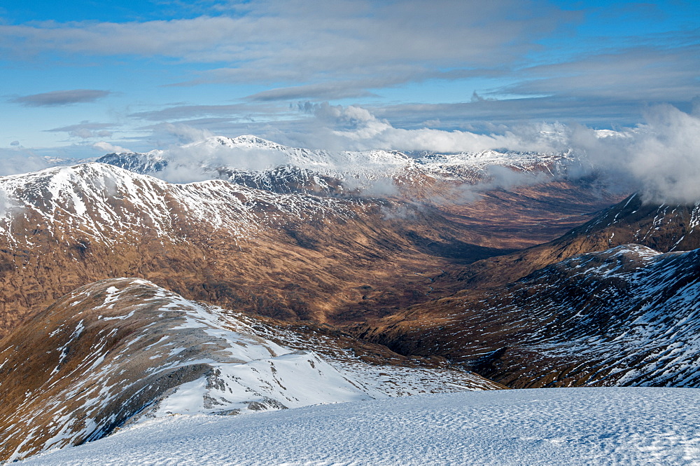 Looking down into Fionngleann in winter from Brothers Ridge in Kintail with the hills of Wester Ross in distance, Highlands, Scotland, United Kingdom, Europe