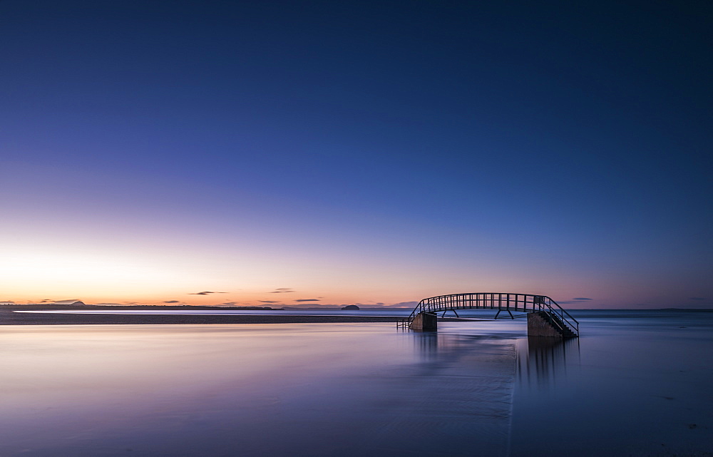 Known as The Bridge To Nowhere, bridge over Biel Water where it flows into Belhaven Bay and the North Sea at Dunbar at sunset, East Lothian, Scotland, United Kingdom, Europe