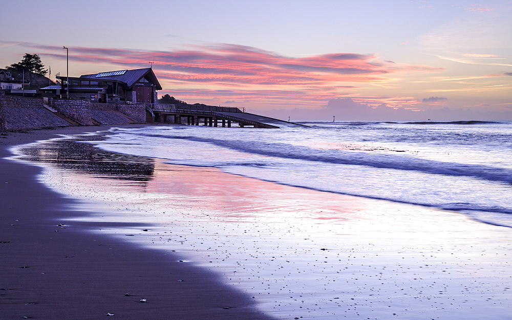 Tranquil dawn with the RNLI Station reflected in the wet beach, Exmouth, Devon, England, United Kingdom, Europe