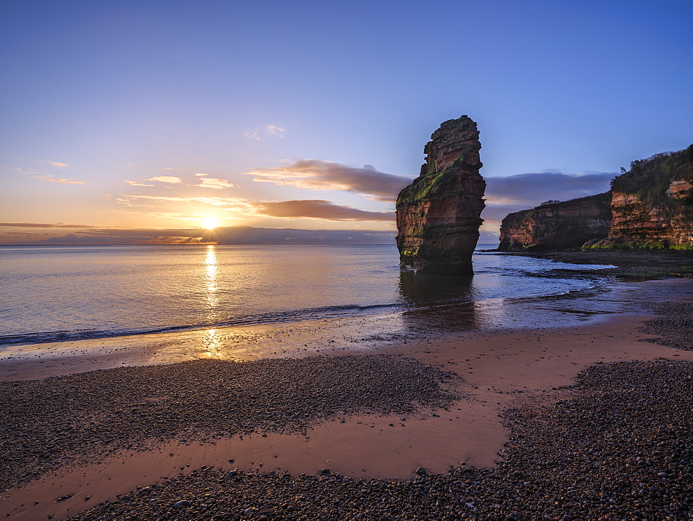 Dawn on the beach with one of the majestic sea stacks at Ladram Bay, Sidmouth, Devon, England, United Kingdom, Europe