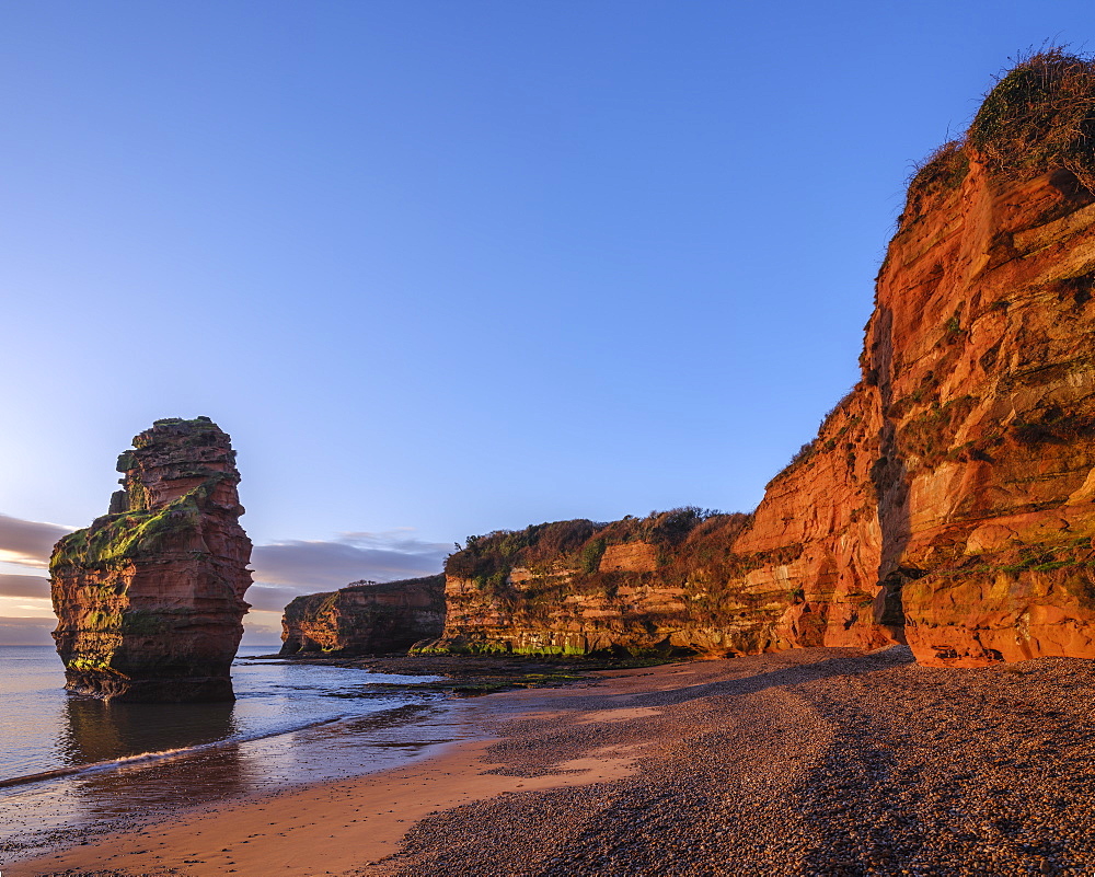 Dawn on the beach with one of the majestic sea stacks at Ladram Bay, Sidmouth, Devon, England, United Kingdom, Europe