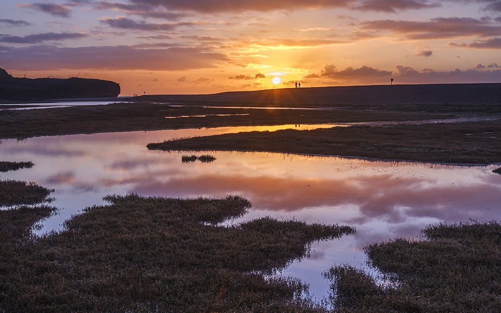 Dogwalkers have a sunrise chat with perfect reflections on the River Otter at Budleigh Salterton, Devon, England, United Kingdom, Europe