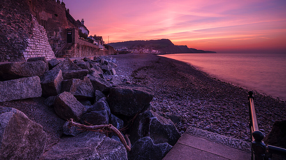 Vivid dawn twilight looking along the beach at the picturesque seaside town of Sidmouth, Devon, England, United Kingdom, Europe