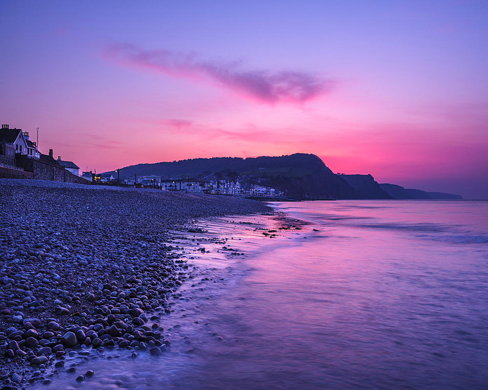 Vivid dawn twilight looking along the beach at the picturesque seaside town of Sidmouth, Devon, England, United Kingdom, Europe