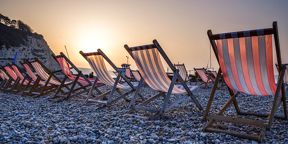 Fishing boats and deckchairs on the popular pebble beach at Beer near Seaton, Devon, England, United Kingdom, Europe