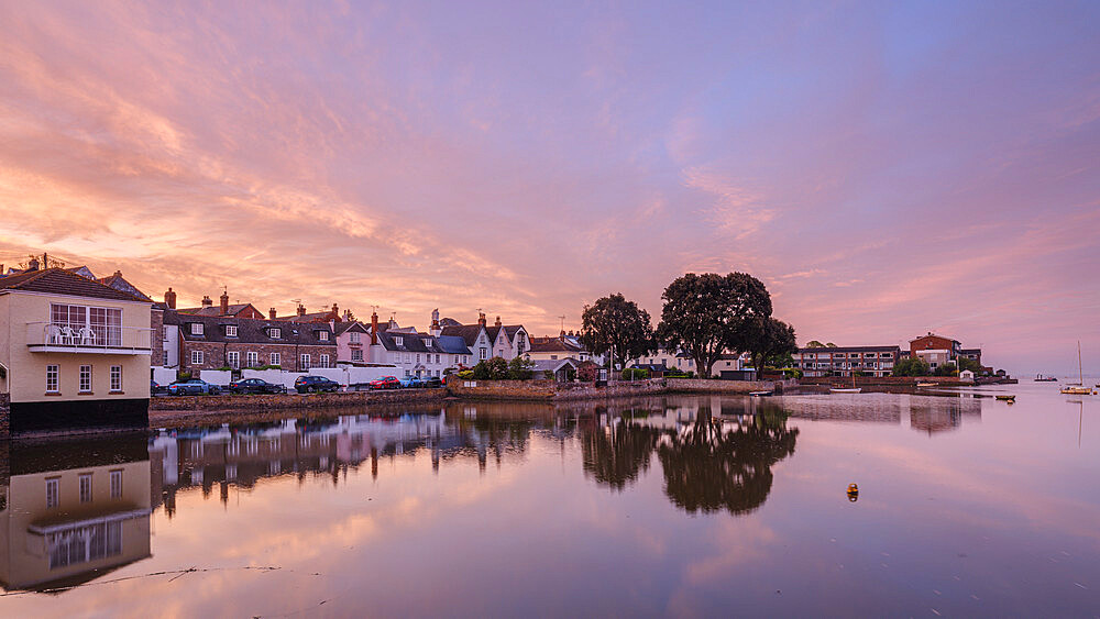 Soft dawn sky over riverside properties with a mirror calm River Exe at Topsham, Devon, England, United Kingdom, Europe