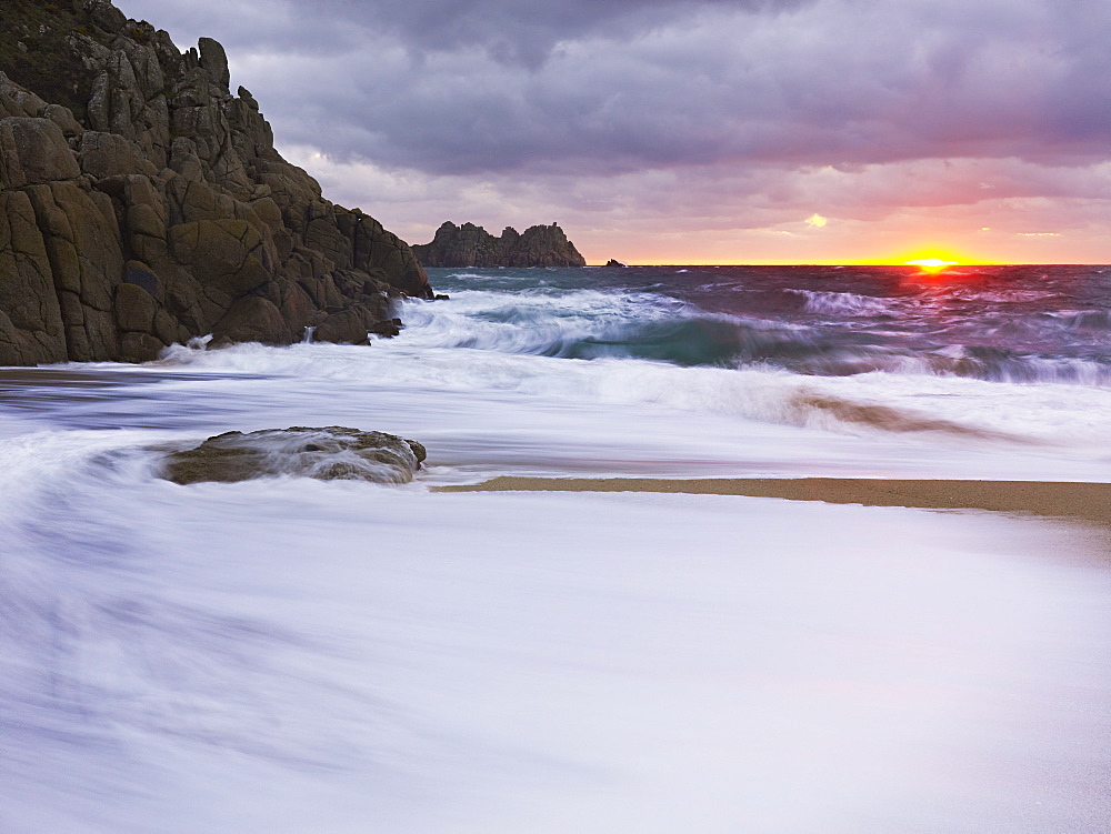 Early morning on the beach looking out towards Logan Rock at Porthcurno, Cornwall, England, United Kingdom, Europe