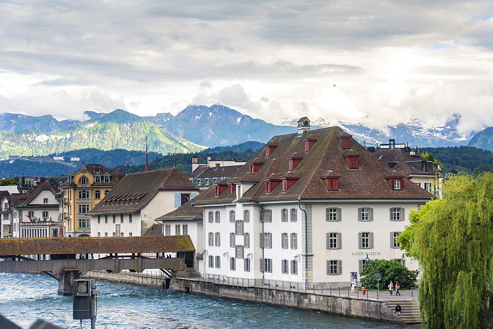 Historic old buildings with Spreuer wooden bridge on the Reuss and mountains in the background, Lucerne, Switzerland, Europe