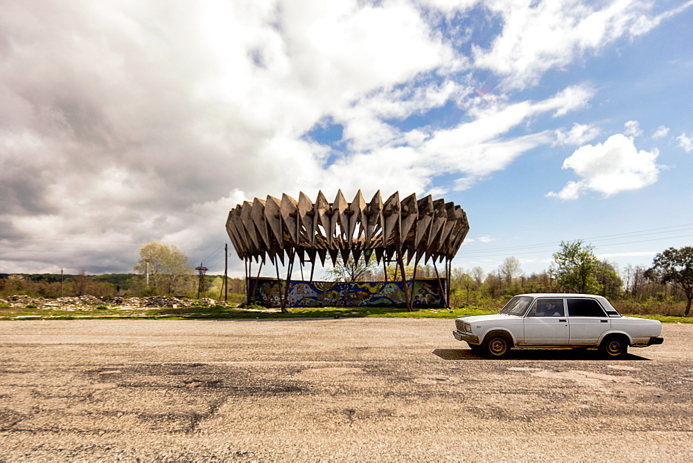 A car passes a soviet bus stop in Abkhazia, Georgia, Central Asia, Asia