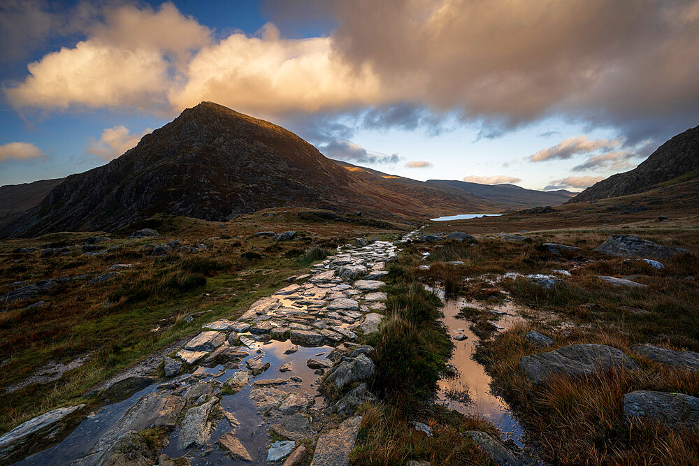 Stone footpath leading towards Llyn Ogwen with view of Tryfan in Snowdonia National Park. Ogwen, Conwy, Wales