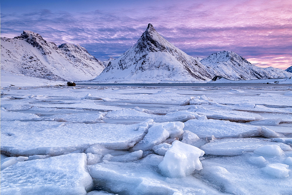 Snow covered steep mountain with frozen river on Lofoten Islands, Arctic, Norway, Europe