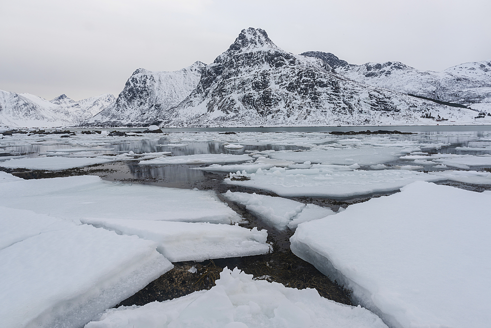 Cracked ice and snow covered mountains, Lofoten Islands, Nordland, Arctic, Norway, Europe