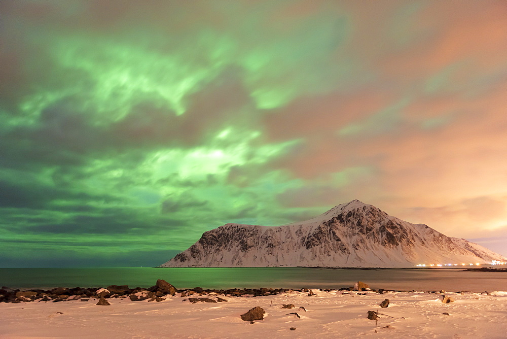 The Northern Lights (Aurora borealis) with mountain range in winter, Reine, Lofoten Islands, Nordland, Arctic, Norway, Europe