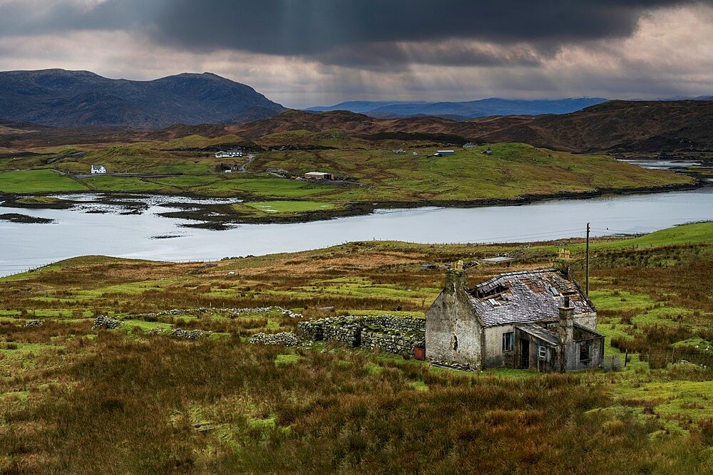 Abandoned croft backed by Loch Eireasort and the Harris Hills, near Baile Ailein, Isle of Lewis, Outer Hebrides, Scotland, United Kingdom, Europe