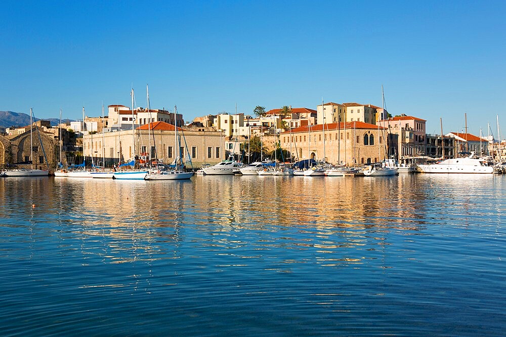 View across the Old Harbour, early morning, quayside buildings reflected in water, Hania (Chania), Crete, Greek Islands, Greece, Europe