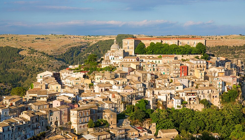 View over the sunlit rooftops of Ragusa Ibla, evening, houses clinging to steep hillside, Ragusa, UNESCO World Heritage Site, Sicily, Italy, Europe