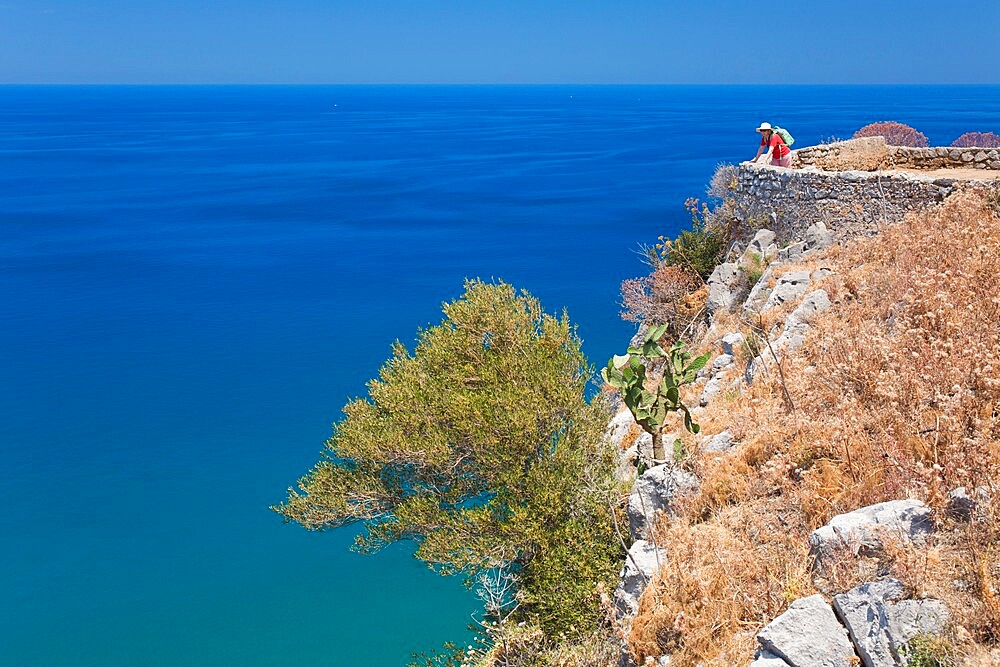 Lone visitor admiring view over the Tyrrhenian Sea from summit of La Rocca, Cefalu, Palermo, Sicily, Italy, Mediterranean, Europe