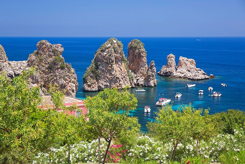 View from hillside over tranquil cove to the Faraglioni, a series of offshore rock stacks, Scopello, Trapani, Sicily, Italy, Mediterranean, Europe