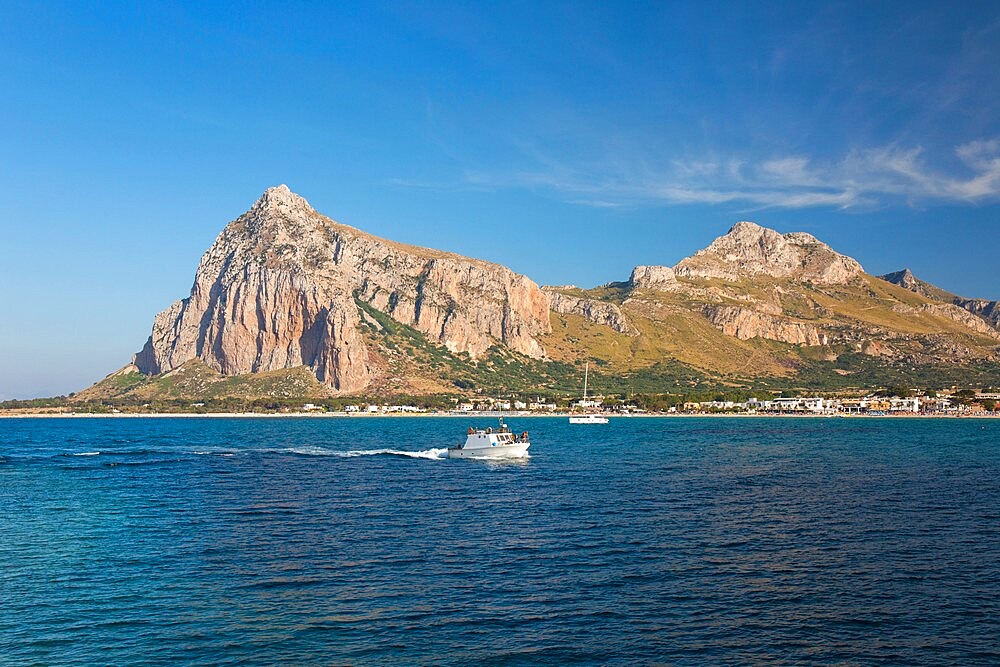 View across the bay to Monte Monaco and Pizzo di Sella, small boat returning to port, San Vito Lo Capo, Trapani, Sicily, Italy, Mediterranean, Europe