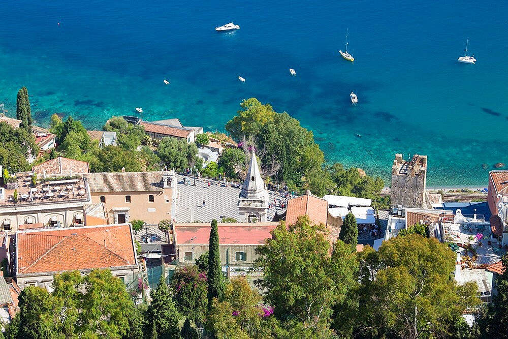 View down steep hillside over rooftops to Piazza IX Aprile and the Ionian Sea below, Taormina, Messina, Sicily, Italy, Mediterranean, Europe