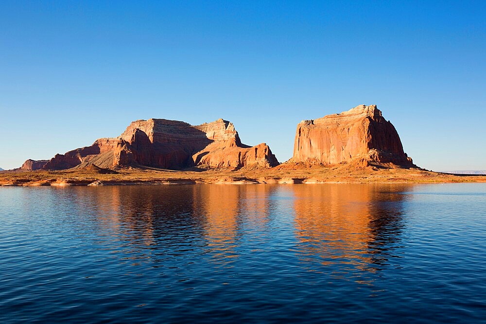 Sandstone cliffs reflected in the tranquil waters of Lake Powell, Glen Canyon National Recreation Area, Utah, United States of America, North America