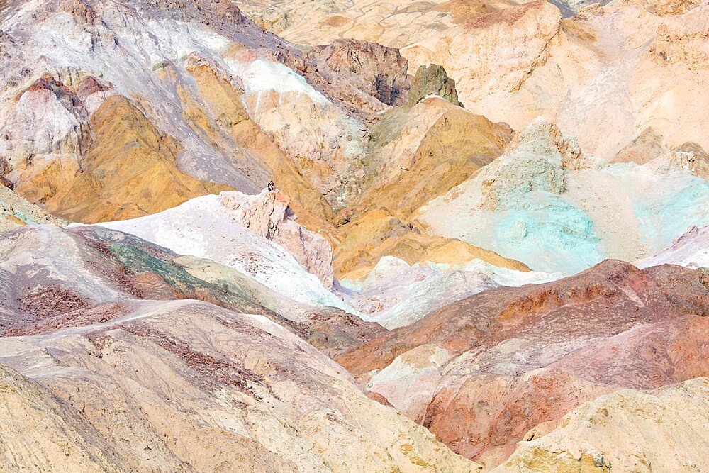 Visitor dwarfed by landscape of colourful rocks, Artist's Palette, Furnace Creek, Death Valley National Park, California, United States of America, North America