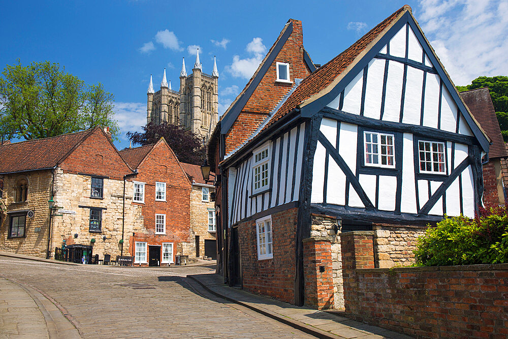 View up cobbled Michaelgate to Lincoln Cathedral, crooked half-timbered house in foreground, Lincoln, Lincolnshire, England, United Kingdom, Europe