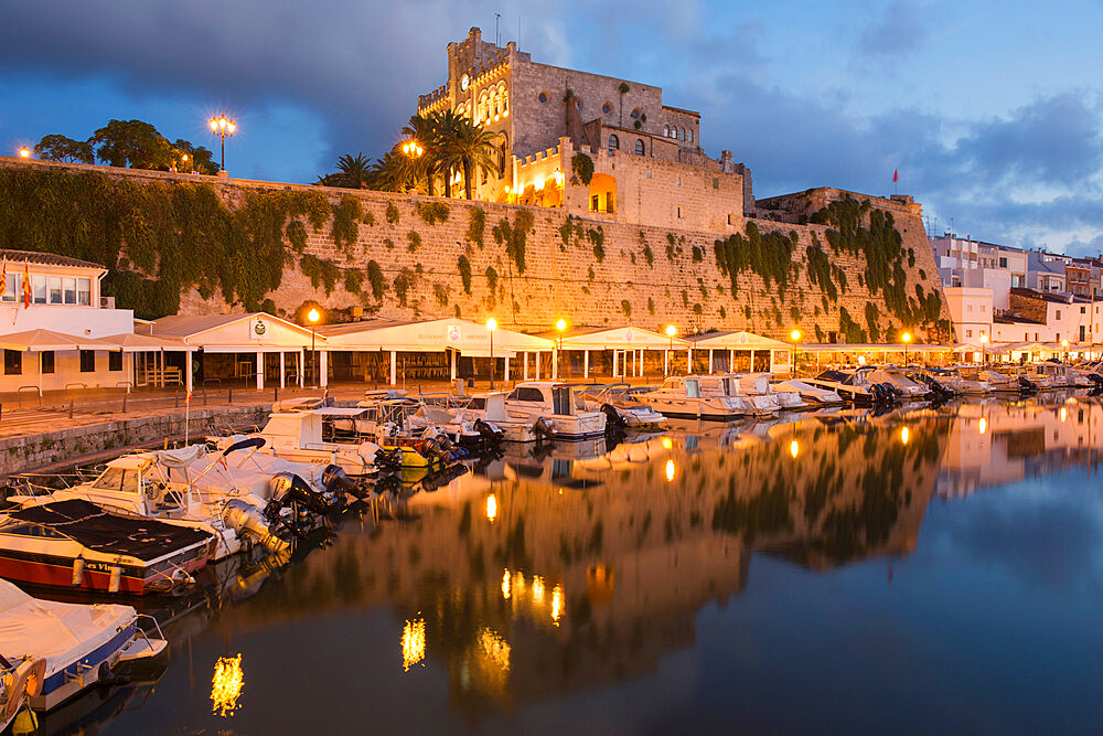 View across tranquil harbour to the illuminated Town Hall at dusk, Ciutadella (Ciudadela), Menorca, Balearic Islands, Spain, Mediterranean, Europe