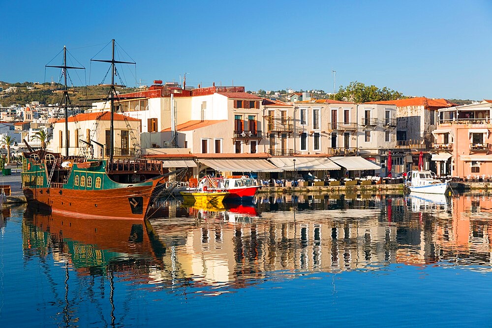 View across the Venetian Harbour, quayside buildings reflected in still water, Rethymno (Rethymnon), Crete, Greek Islands, Greece, Europe