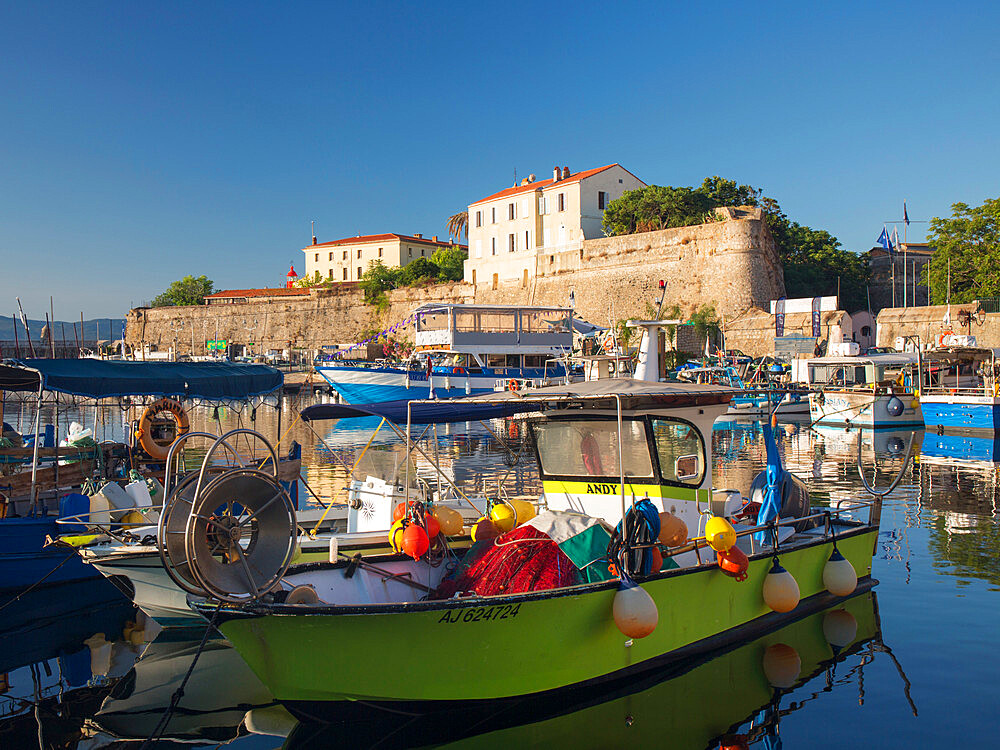 View across tranquil harbour to the citadel, sunrise, typical fishing boat in foreground, Ajaccio, Corse-du-Sud, Corsica, France, Mediterranean, Europe