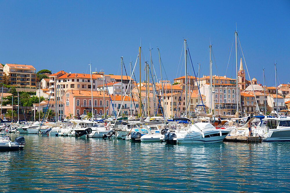 View across marina to the town, yachts and motor boats reflected in tranquil water, Calvi, Haute-Corse, Corsica, France, Mediterranean, Europe