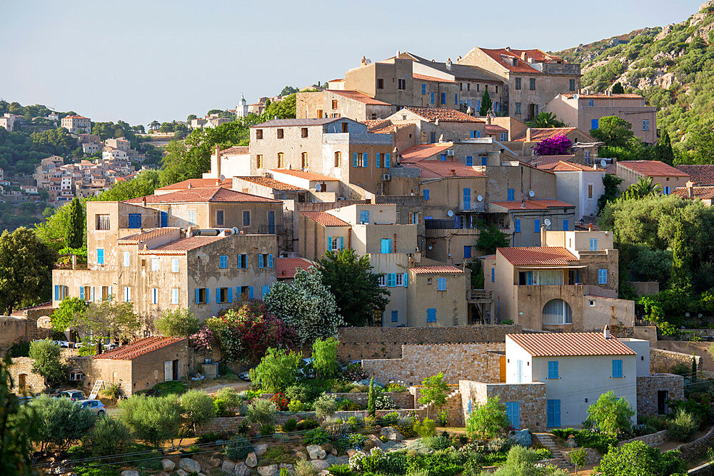 Village houses perched on steep hillside, Corbara in background, Pigna, L'Ile-Rousse Balagne, Haute-Corse, Corsica, France, Mediterranean, Europe