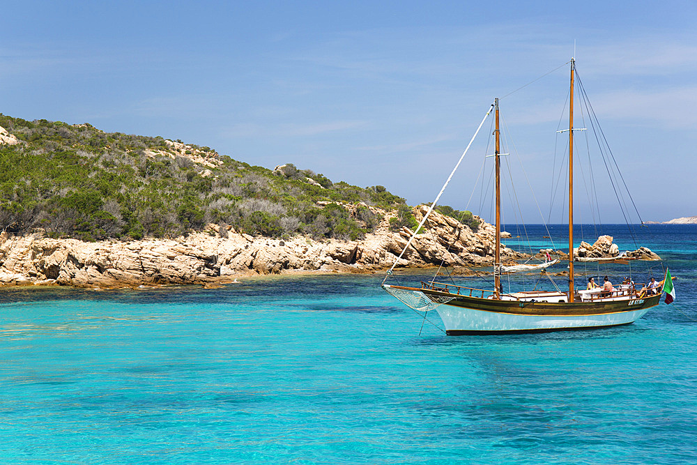 Wooden sailing boat anchored in clear turquoise water off Cala Granara, Spargi Island, La Maddalena Archipelago National Park, Sassari, Sardinia, Italy, Mediterranean, Europe