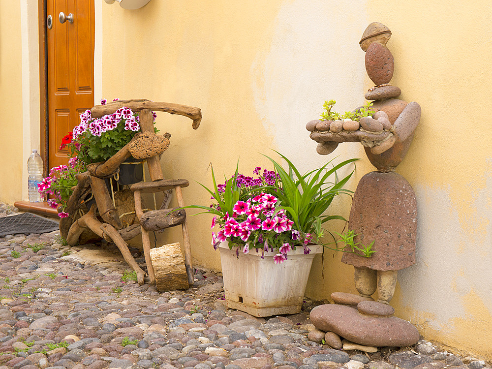 Artistic display of wood, stones and flowers adorning cobbled Via Ospedale in the heart of the Old Town, Alghero, Sassari, Sardinia, Italy, Mediterranean, Europe