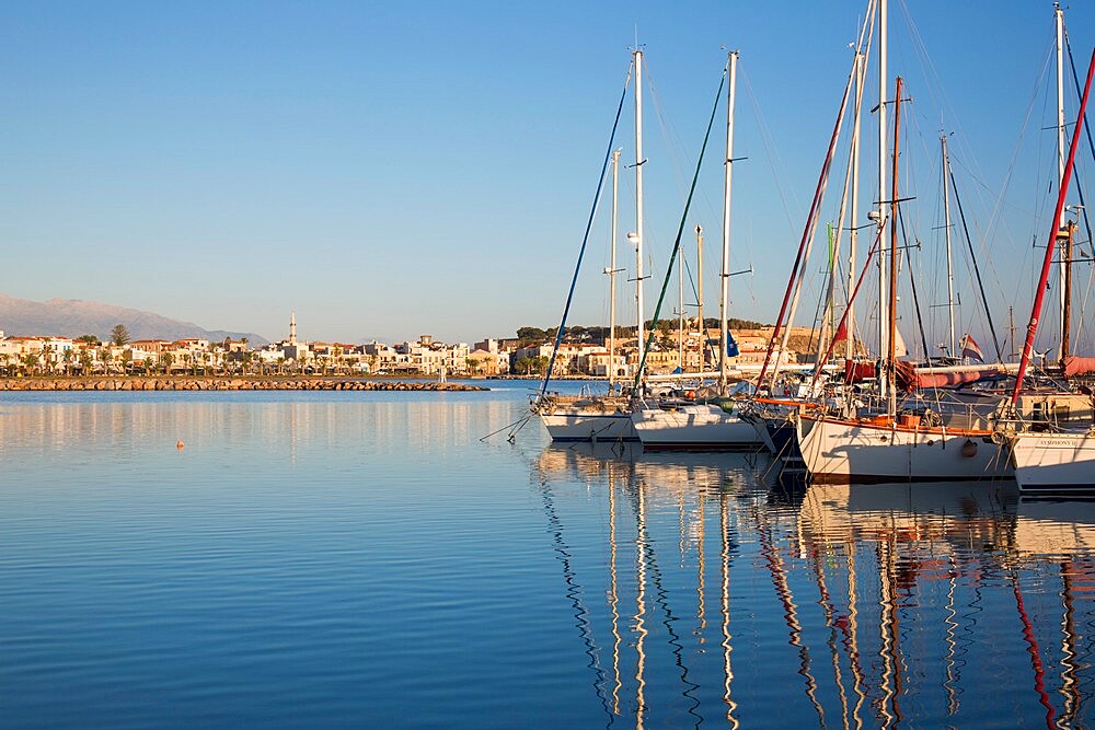 Yachts reflected in the still waters of the marina, early morning, Rethymno (Rethymnon), Crete, Greek Islands, Greece, Europe