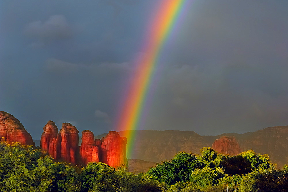 A purely accidental photo of a rainbow intersecting Coffee Pot Rock in Sedona, Arizona, United States of America, North America