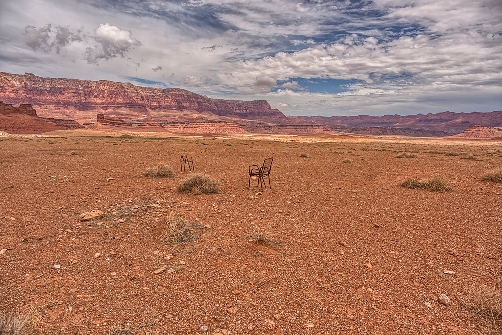 An abandoned lawn chair in view of Vermilion Cliffs near Marble Canyon Arizona from US89A on a mostly cloudy day. Located between the little town of Bitter Springs on the Navajo Reservation and the Vermilion Cliffs National Monument.