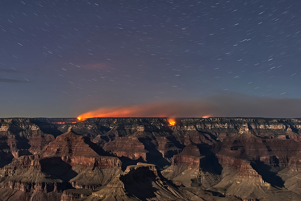 Dragon Bravo Wildfire on Grand Canyon North Rim viewed from Yavapai Point on South Rim Arizona at night under moonlight.