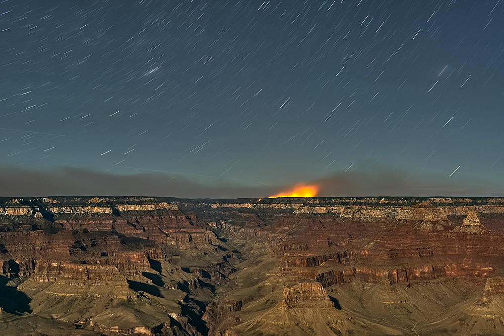 Dragon Bravo Wildfire on Grand Canyon North Rim viewed from Yavapai Point on South Rim Arizona at night under moonlight.