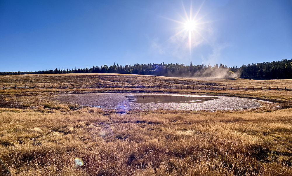 Deer Lake Sinkhole on the Kaibab Plateau in northern Arizona near sunset. The wood fence is to keep cattle from getting stuck in the hole.