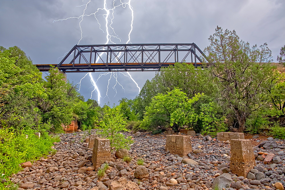 Lightning from a monsoon storm striking behind an old railroad trestle bridge that spans Bear Canyon near Perkinsville, Arizona, United States of America, North America