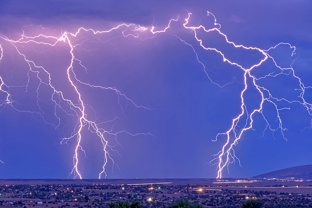 Lightning bolts striking Prescott area in the distance with the town of Chino Valley just north of Prescott Town in the foreground, Arizona, United States of America, North America