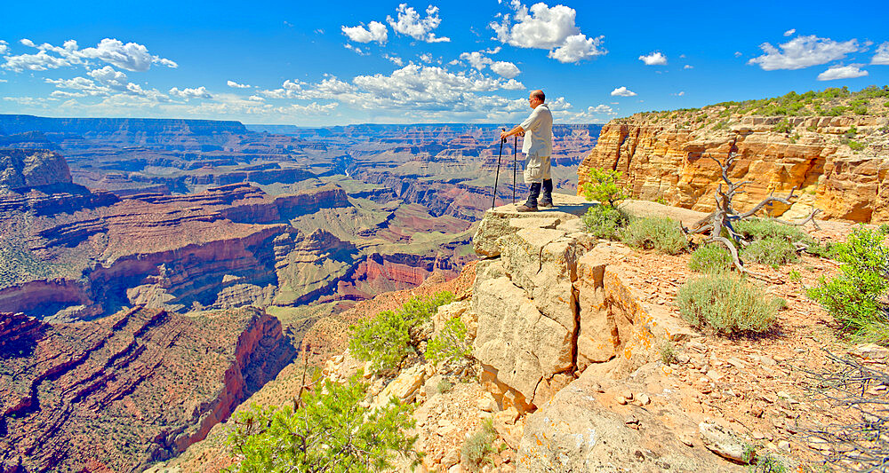 A hiker looking west from a cliff near Zuni Abyss at Grand Canyon, Zuni Point in the background just right of center, Grand Canyon National Park, UNESCO World Heritage Site, Arizona, United States of America, North America