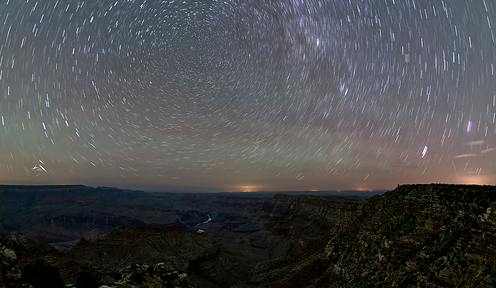 The swirl of stars in the night sky over Grand Canyon South Rim viewed from Navajo Point with the historic Watchtower in the distance on the right, Grand Canyon National Park, UNESCO World Heritage Site, Arizona, United States of America, North America