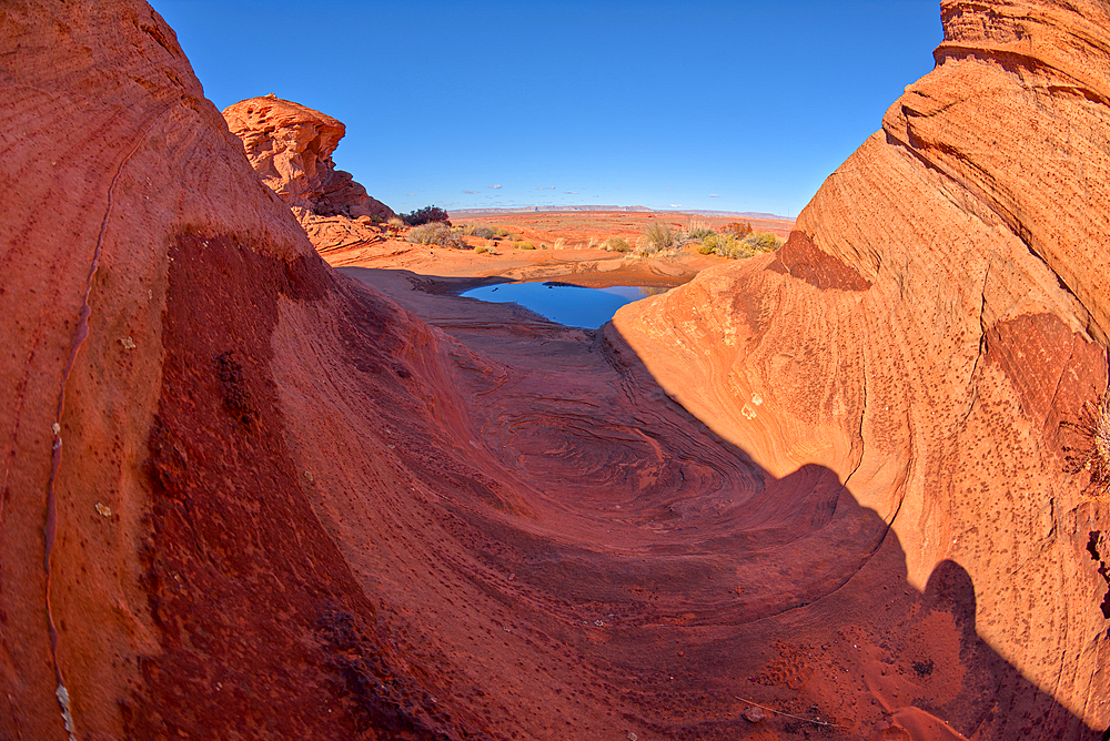 A wavy sandstone formation with a puddle of water north of the Horseshoe Bend Overlook along the Colorado River in Page, Arizona, United States of America, North America